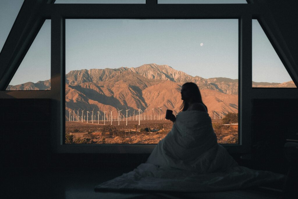 A woman looking out of a window of an Airbnb hotel